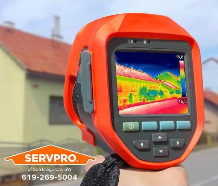An infrared camera is pointed at a property to detect temperature variations.