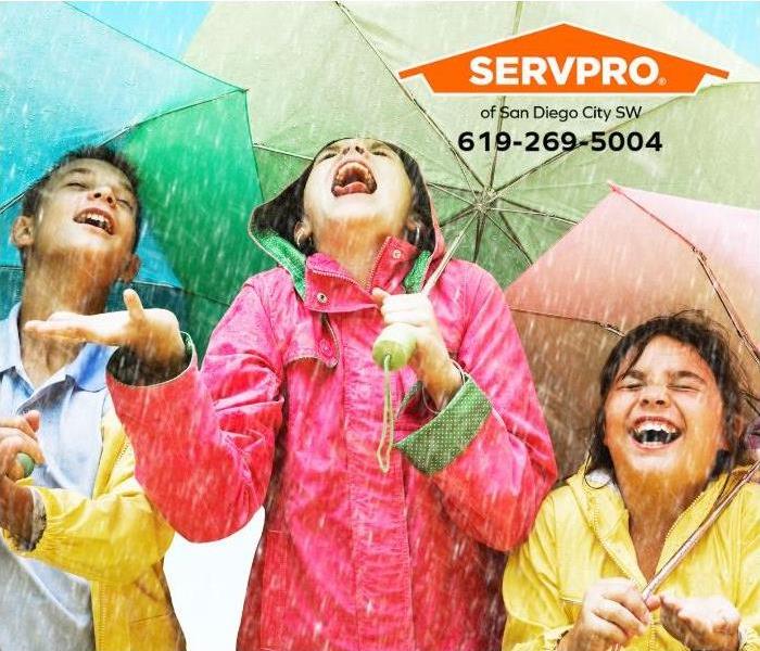 Kids with umbrellas enjoy being outside during a rainstorm.