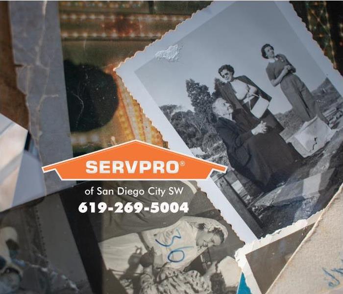 A pile of photographs rescued from a house fire any strew on top of a table.